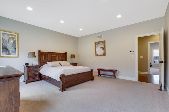 bedroom with recessed lighting, visible vents, light carpet, and baseboards