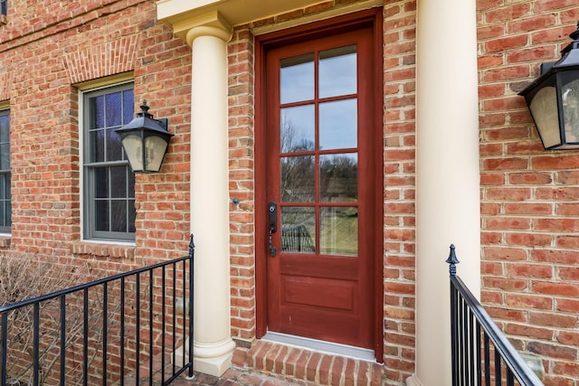 entrance to property featuring brick siding