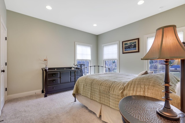 bedroom with baseboards, recessed lighting, and light colored carpet