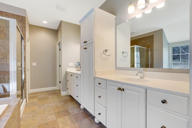 bathroom featuring a relaxing tiled tub, baseboards, stone finish floor, vanity, and a shower stall