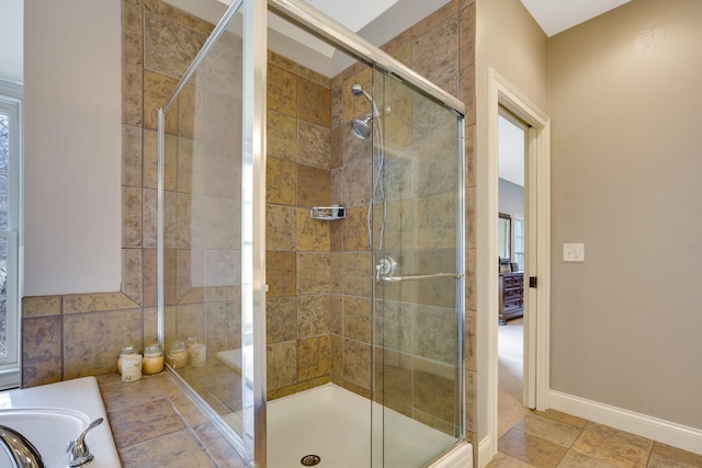 bathroom with a sink, a shower stall, and baseboards