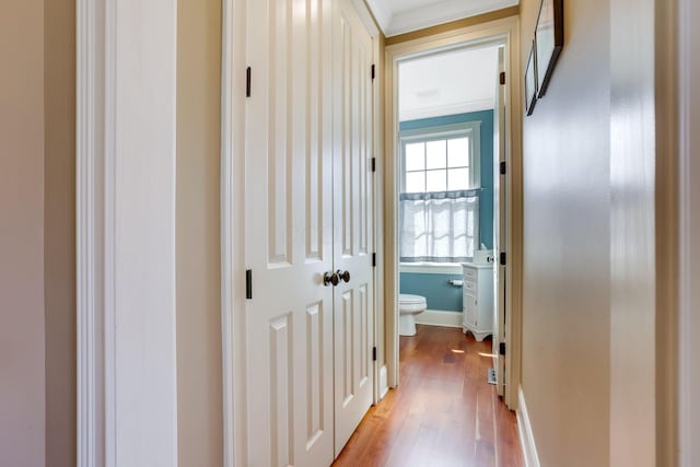 hall with baseboards and light wood-style floors