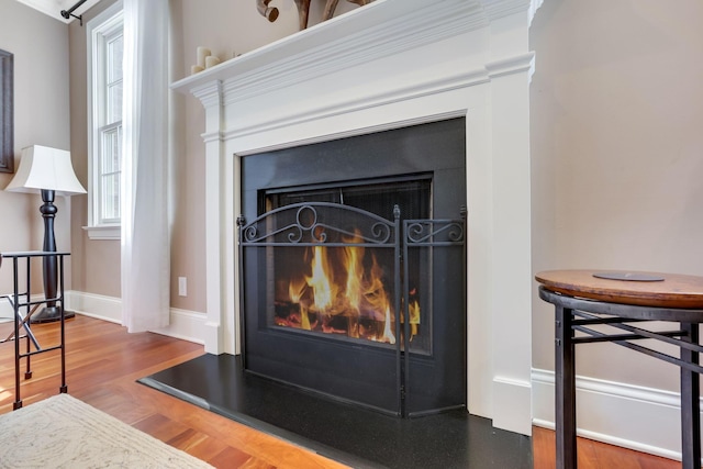 interior details with a fireplace, baseboards, and wood finished floors