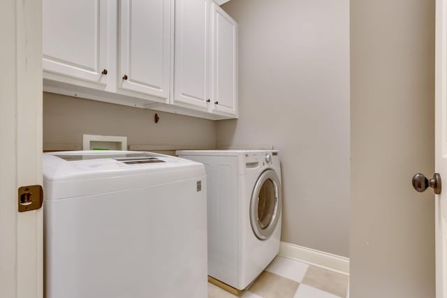 laundry area featuring cabinet space, washing machine and dryer, and baseboards