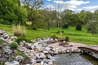 view of community featuring a fire pit and a lawn