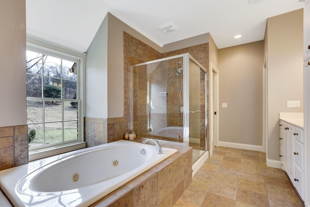 full bathroom featuring plenty of natural light, a shower stall, a tub with jets, and vanity