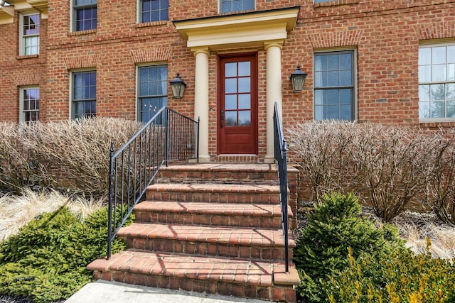 entrance to property featuring brick siding