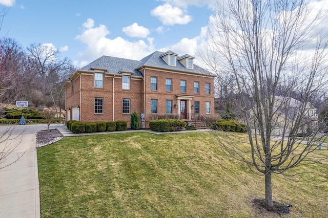 view of front of home with a garage, brick siding, concrete driveway, and a front yard