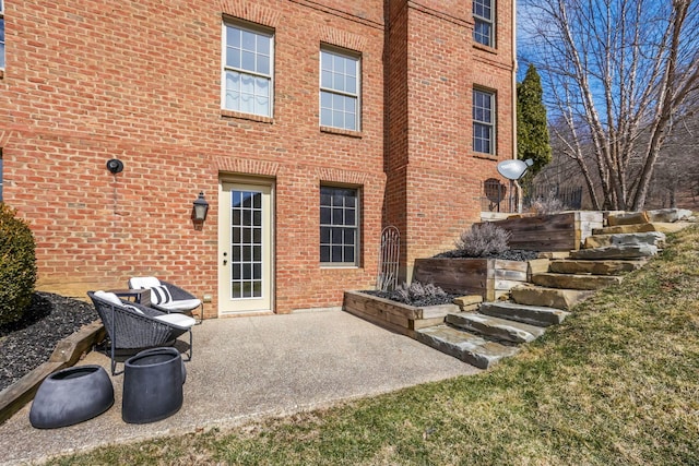 rear view of house with brick siding and a patio area