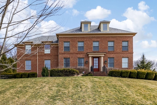 colonial house with a front yard and brick siding