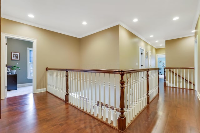 corridor featuring baseboards, ornamental molding, wood finished floors, an upstairs landing, and recessed lighting