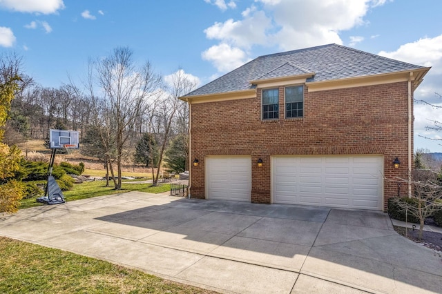 view of property exterior featuring driveway, an attached garage, a shingled roof, and brick siding