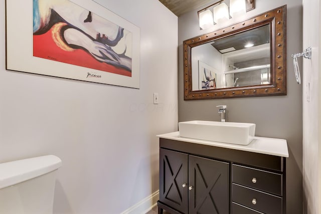 bathroom with vanity, toilet, and baseboards