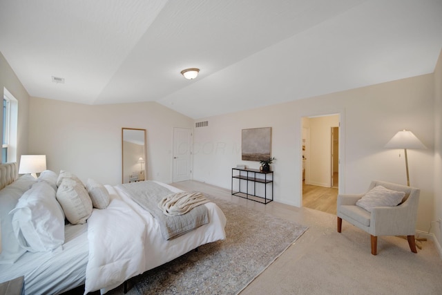 bedroom with vaulted ceiling, visible vents, and light carpet