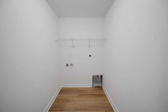 laundry area with baseboards, hookup for an electric dryer, laundry area, washer hookup, and light wood-type flooring