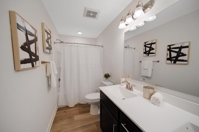 bathroom featuring visible vents, toilet, a shower with shower curtain, wood finished floors, and vanity