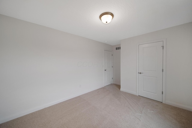 unfurnished bedroom with visible vents, baseboards, and light colored carpet