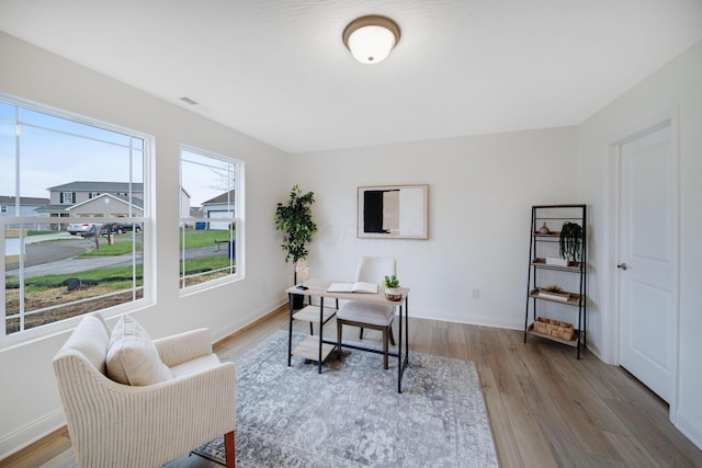 office area featuring visible vents, baseboards, and light wood finished floors