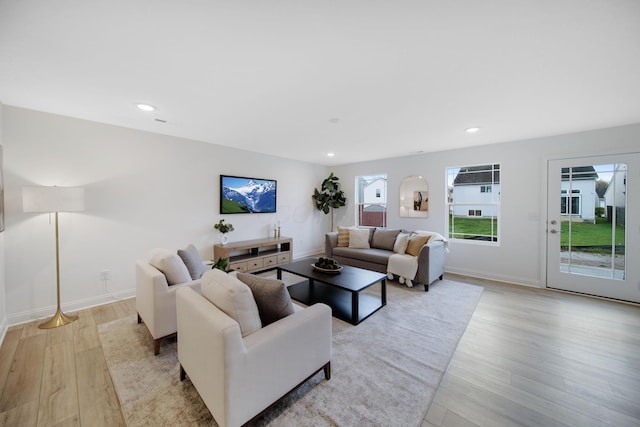 living area featuring recessed lighting, light wood-type flooring, and baseboards