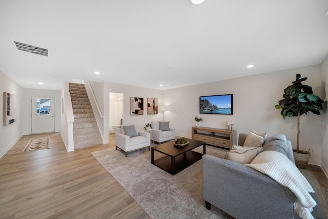 living room with visible vents, light wood-style flooring, recessed lighting, stairway, and baseboards