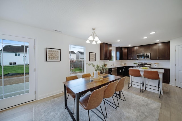 dining area with recessed lighting, visible vents, light wood-style floors, and a chandelier