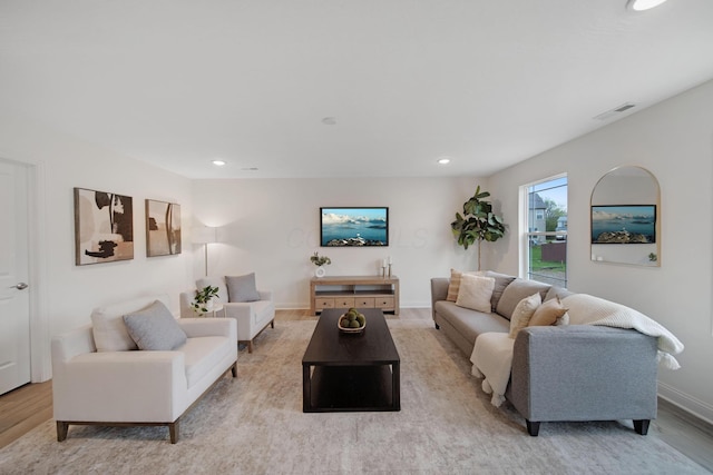 living room with recessed lighting, visible vents, baseboards, and wood finished floors