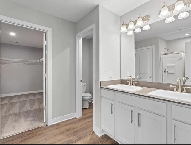 full bath featuring a sink, visible vents, toilet, and a shower stall