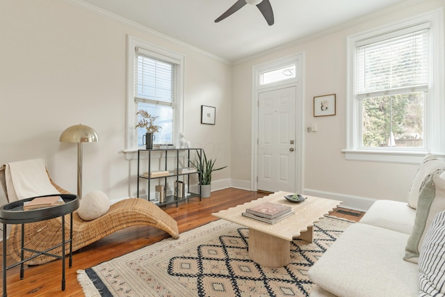 living room with baseboards, ornamental molding, and wood finished floors