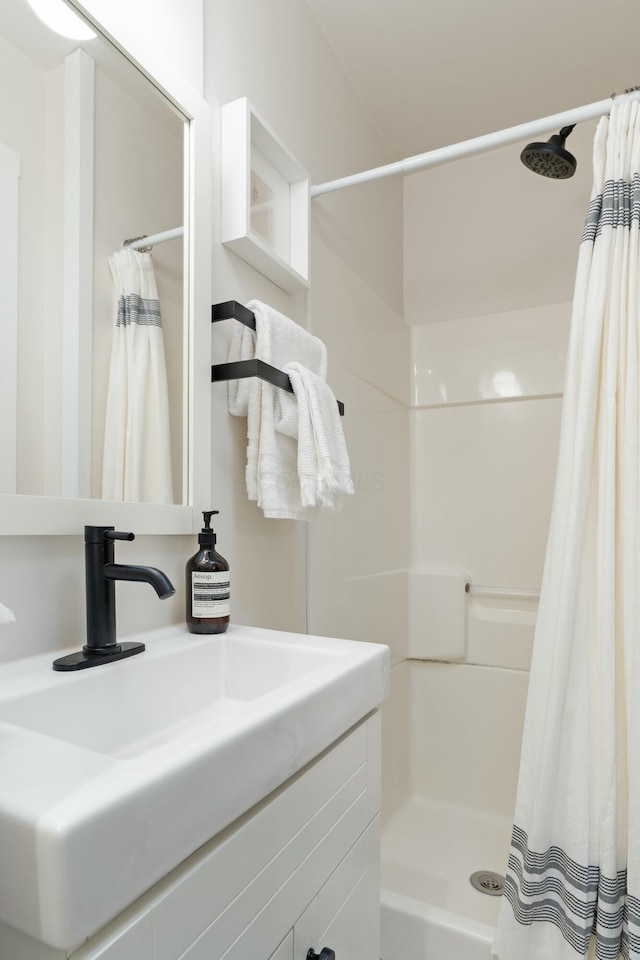 bathroom with a shower stall and vanity