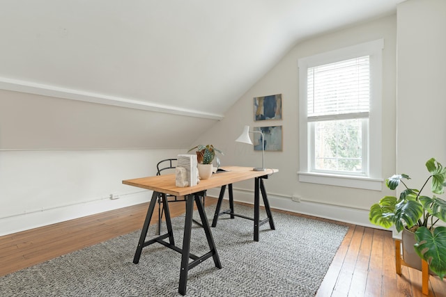 office space with baseboards, vaulted ceiling, and hardwood / wood-style floors