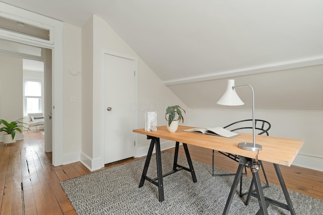 office area featuring lofted ceiling, baseboards, and hardwood / wood-style floors