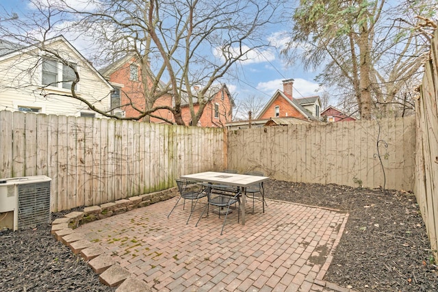 view of patio with outdoor dining area, a fenced backyard, and central air condition unit