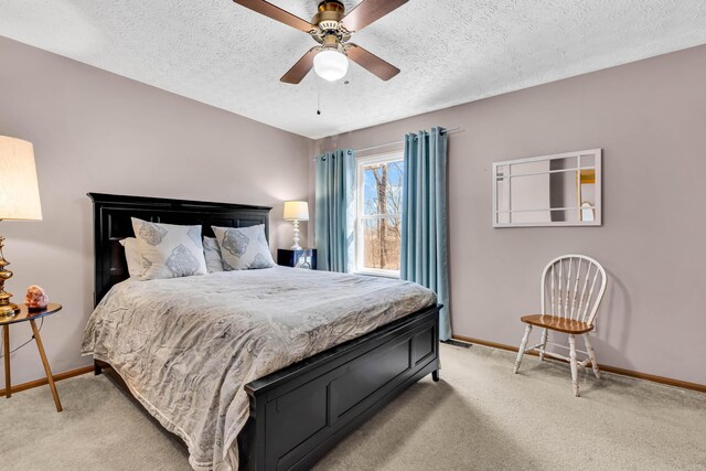 bedroom with a textured ceiling, a ceiling fan, baseboards, and light carpet