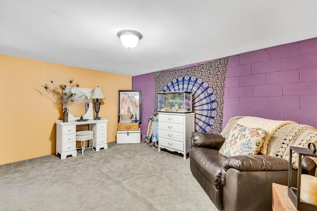 living area with concrete block wall and carpet floors