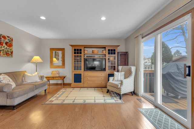 living area featuring light wood finished floors, visible vents, and recessed lighting