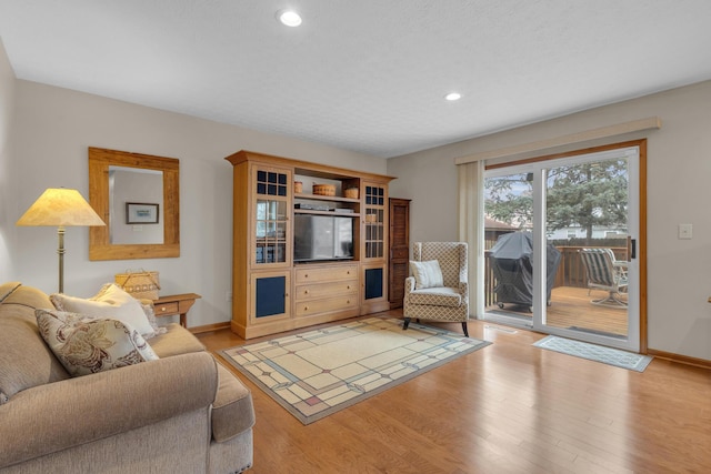 living room with light wood-style flooring, baseboards, and recessed lighting