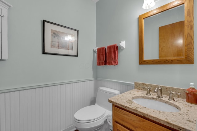 bathroom featuring wainscoting, vanity, and toilet