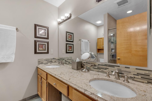 full bathroom featuring visible vents, a sink, backsplash, and a shower stall