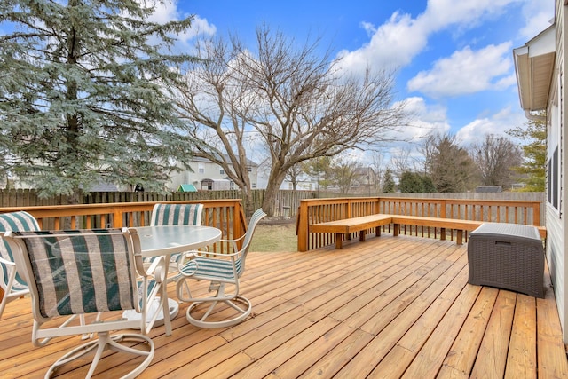 wooden terrace featuring outdoor dining space and a fenced backyard