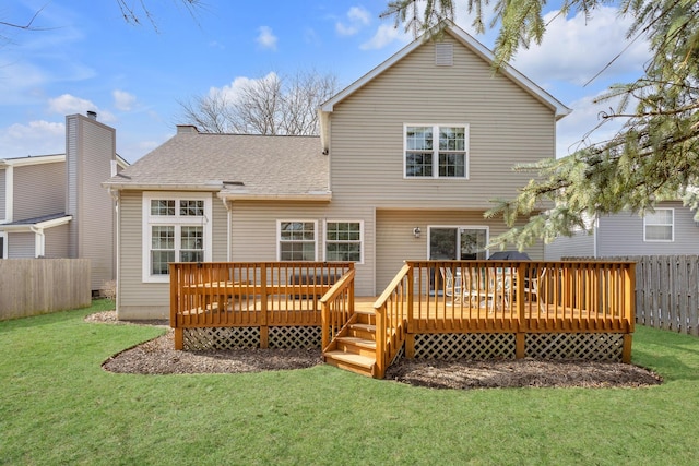 rear view of property with a deck, a yard, roof with shingles, and fence