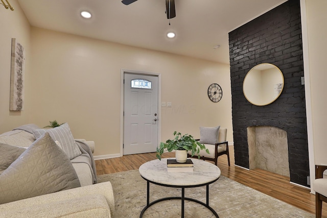 living room with baseboards, wood finished floors, a ceiling fan, and recessed lighting