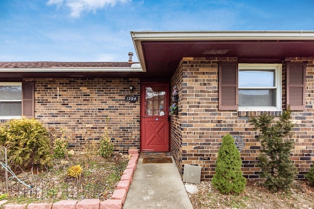 doorway to property featuring brick siding