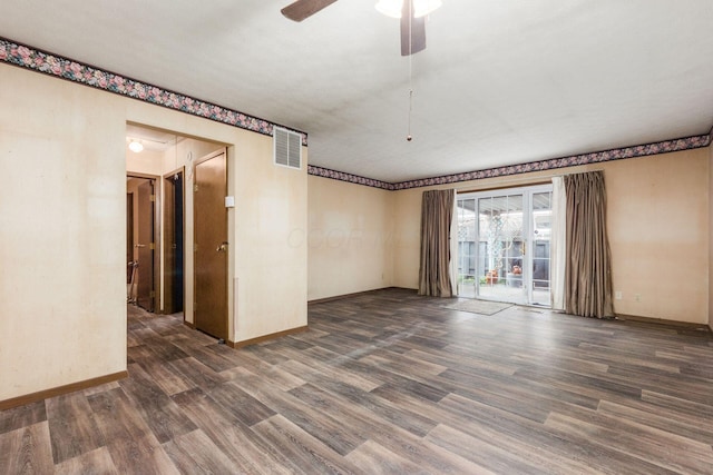 spare room with a ceiling fan, wood finished floors, visible vents, and baseboards