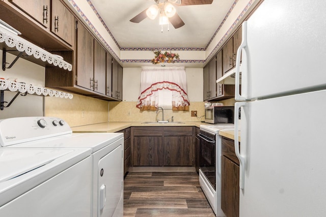 kitchen featuring white appliances, dark wood-style flooring, a sink, light countertops, and washer and clothes dryer