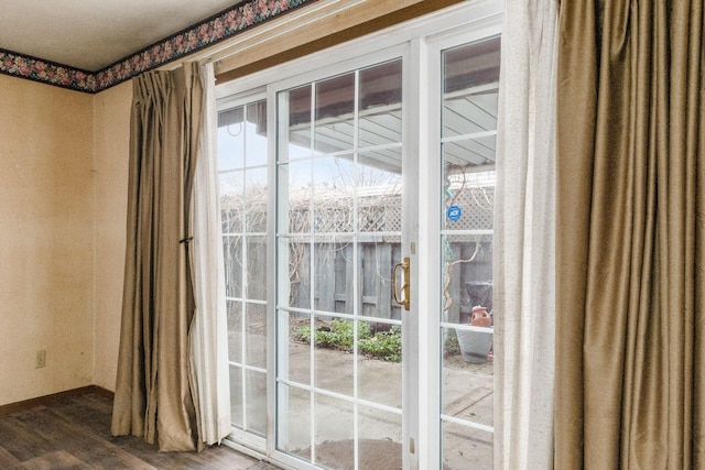 doorway to outside with a wealth of natural light and wood finished floors