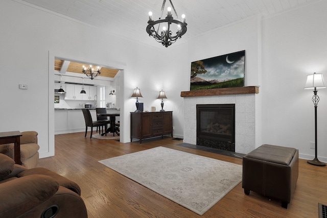 living area featuring visible vents, a tile fireplace, wooden ceiling, wood finished floors, and a notable chandelier