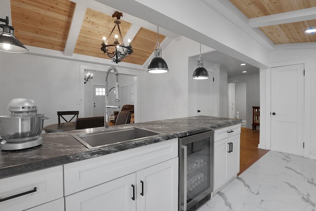 kitchen featuring wine cooler, marble finish floor, lofted ceiling with beams, white cabinets, and wooden ceiling