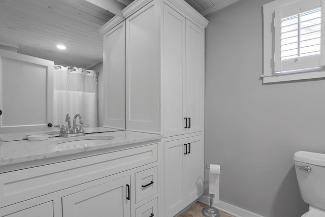 full bath with baseboards, vanity, and toilet