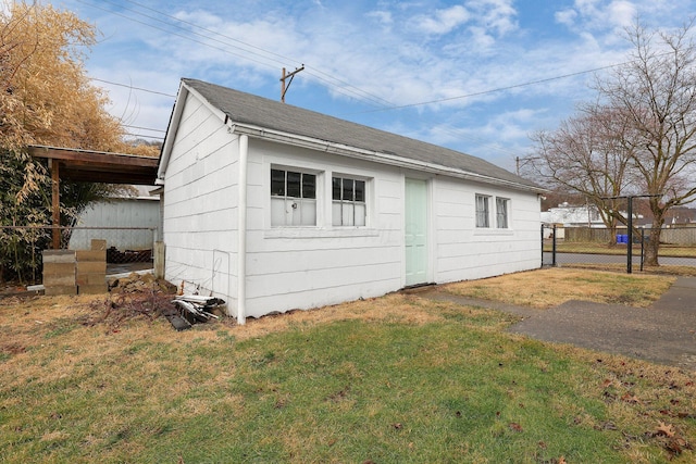 exterior space with a lawn, an outdoor structure, and fence