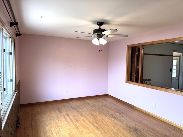 empty room with visible vents, baseboards, ceiling fan, and wood-type flooring